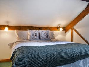 a bedroom with a large bed with a wooden headboard at The Shippon in Appletreewick