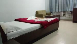 Un dormitorio con una cama con una manta roja. en HOTEL MTM, en Digha