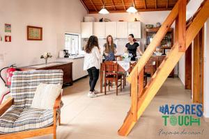 three women standing in a kitchen with a table at Casa da Rocha in Santa Bárbara