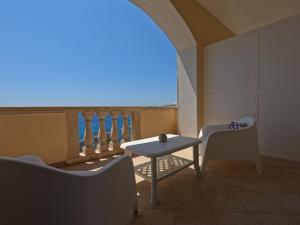 a room with a table and chairs and a view of the ocean at B&B The Sun 'tis in Castro di Lecce