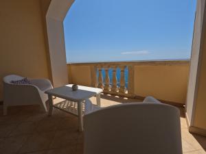 einen Balkon mit einem Tisch und Stühlen sowie Meerblick in der Unterkunft B&B The Sun 'tis in Castro di Lecce