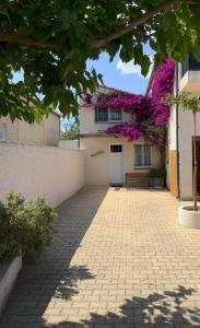 un bâtiment avec des fleurs violettes sur son côté dans l'établissement La Perdrix, à Argelès-sur-Mer