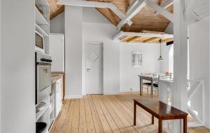 uma cozinha e sala de jantar com paredes brancas e pisos em madeira em Gorgeous Apartment In Hjer With Kitchen em Højer