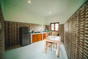 een keuken met een houten tafel en een bakstenen muur bij Pondok Ubud Nia Cahya in Tegalalang