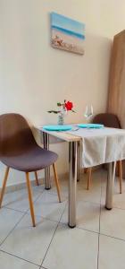 a table and a chair and a table with a flower on it at Alex Downtown Studio in Argostoli +4 photos