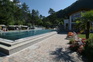 a swimming pool in front of a house at Schwimmbad Camping Mössler in Döbriach