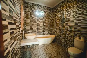 een badkamer met een bad en een toilet bij Pondok Ubud Nia Cahya in Tegalalang
