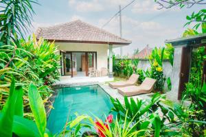 een villa met een zwembad en een huis bij Pondok Ubud Nia Cahya in Tegalalang