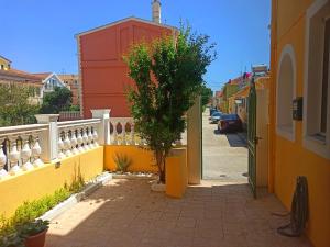 a street with a yellow fence and a tree at Alex Downtown Studio in Argostoli