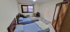 um pequeno quarto com 2 camas e uma janela em ستوديو على البحر محطة الرمل Raml station stodeo em Alexandria