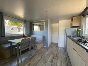 eine Küche und ein Esszimmer mit einem Tisch in einem Wohnwagen in der Unterkunft International Camping Ardèche in Salavas