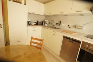 蘭圖姆的住宿－Mini Beach House II，厨房配有白色橱柜、桌子和水槽。