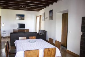 een woonkamer met een tafel en een bank bij Casa Lagar de Pedra T3 in Santa Cruz da Graciosa