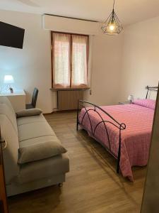 a bedroom with a bed and a couch and a chair at Appartamento Belvedere in Perugia