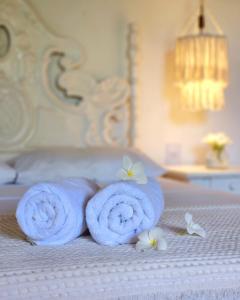 um par de toalhas numa cama com flores em Pousada Almar em Pipa