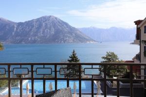 uma varanda com vista para a água e para as montanhas em Bellezza Resort & SPA em Kotor