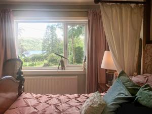 a bedroom with a bed and a window with a view at An Tabhall in Glencripesdale