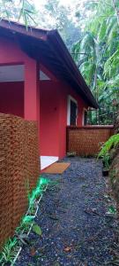 une maison rouge avec une clôture devant elle dans l'établissement Casa da Floresta, à Parati