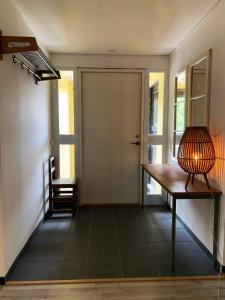 a hallway with a door and a table and a lamp at Haga betong in Enånger