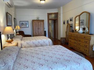 a bedroom with two beds and a dresser at Historic Capitol Hotel Vacation Suites Downtown in Buffalo