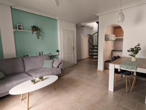 - un salon avec un canapé et une table dans l'établissement Apartamento Las Palmeras - Con Terraza, barbacoa, aire acondicionado y a 250m de la playa!, à Los Alcázares