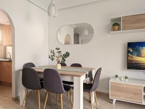 a dining room with a table and chairs at Apartamento Las Palmeras - Con Terraza, barbacoa, aire acondicionado y a 250m de la playa! in Los Alcázares