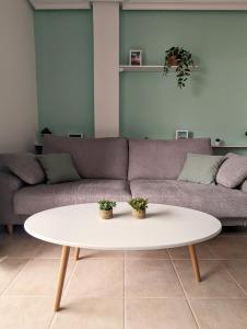 a living room with a couch and a white coffee table at Apartamento Las Palmeras - Con Terraza, barbacoa, aire acondicionado y a 250m de la playa! in Los Alcázares