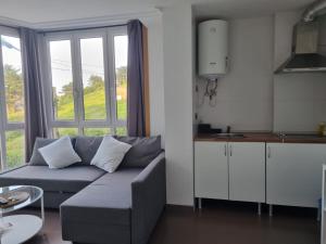 a living room with a couch and a kitchen at Casa As Neves - 1B Gran Ventanal in Malpica