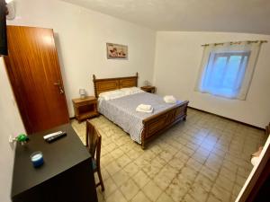 ein Schlafzimmer mit einem Bett, einem Tisch und einem Schreibtisch in der Unterkunft Villa D'Anna in Cefalú