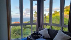 a room with four windows looking out at the ocean at Casa As Neves - 1B Gran Ventanal in Malpica