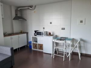 a small kitchen with a table and a microwave at Casa As Neves - 1B Gran Ventanal in Malpica +4 photos