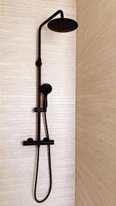 a black shower head hanging on a wall at SUITE HAUS Catedral in Santander