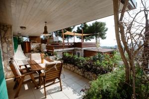 an outdoor patio with a wooden table and chairs at Villa Zdena in Rogač