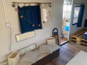 a living room with a couch and a blue curtain at Beach hub caravans Gradina in Chernomorets