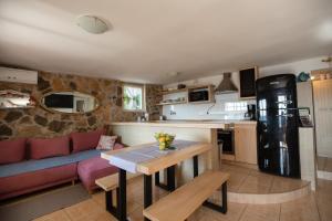 eine Küche und ein Wohnzimmer mit einem Sofa und einem Tisch in der Unterkunft Villa Zdena in Rogač