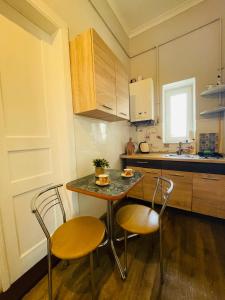 una pequeña cocina con mesa y 2 sillas en Джерельна 25, апартаменти в центрі з двома ізольованими спальнями, en Leópolis