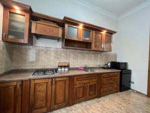 a kitchen with wooden cabinets and a counter top at Green villa panorama in Batumi