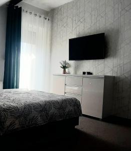 a bedroom with a bed and a television on a wall at Willa Piasutno z klimatyzacją in Świętajno +21 photos