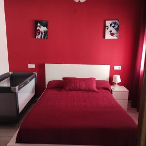 ein rotes Schlafzimmer mit einem Bett mit einer roten Wand in der Unterkunft Apartamento Buendia in Buendía