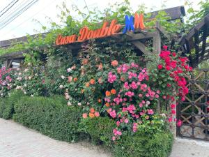 un giardino fiorito con un cartello che dice "pedaggio doppio" di Casa Double M a Vama Veche