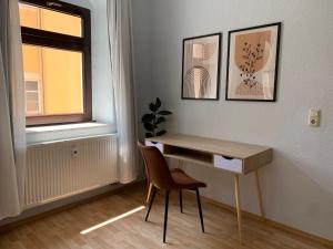 a desk and a chair in a room with a window at Stilvolle Altbauwohnung im Zentrum von Bad Schandau in Bad Schandau