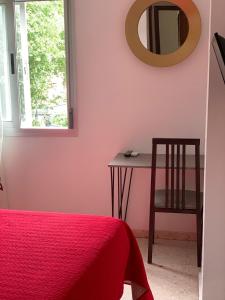 a bedroom with a table and a mirror on the wall at Hostal Mediterraneo in Torre del Mar