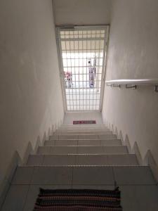 eine Treppe in einem Gebäude mit Fenster darauf in der Unterkunft 365 House by D'Laksamana in Malakka
