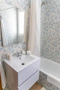 a bathroom with a sink and a mirror and a tub at apartamento playa chica in Barbate +4 photos