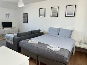 ein Schlafzimmer mit einem Bett und einem Sofa in der Unterkunft Appartement Design VI Port de Tréboul Douarnenez in Douarnenez