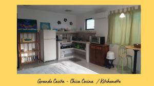 a kitchen with a white refrigerator and a table at Dos Casitas Tranquilo in Progreso