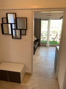 a living room with a couch and a door to a balcony at A 10mn de la plage!! in Cavalaire-sur-Mer