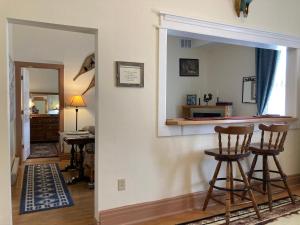 a living room with a mirror and two bar stools at Historic Capitol Hotel Vacation Suites Downtown in Buffalo