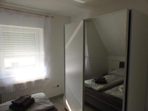 een spiegel in een kamer met 2 bedden en een raam bij Ferienwohnung in Porta Westfalica