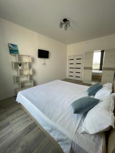 1 dormitorio con 1 cama blanca grande con almohadas en Квартира однокомнатная, en Taldykolʼ